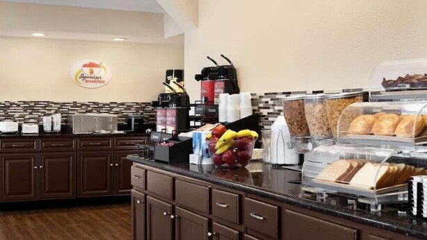 Un espace dédié au petit-déjeuner, équipé d’une machine à café, d’un panier de fruits et d’un présentoir à pain.