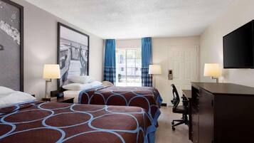 A hotel room with two beds, a desk, a chair, a TV, and a window with curtains.