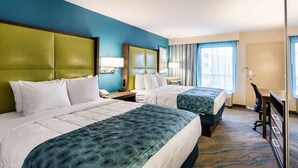 A hotel room with two beds, a desk, and a chair. - Quality Inn Gulfport I-10 (Gulfport)