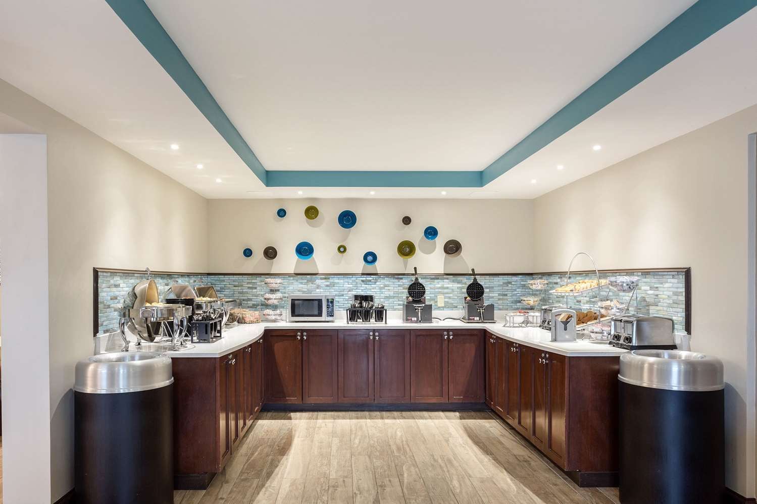 A modern kitchen with a central island, built-in appliances, and a decorative backsplash.