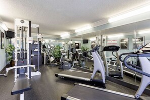 A gym with various exercise equipment including treadmills, weight machines, and a mirrored wall. - Quality Inn Gulfport I-10 (Gulfport)
