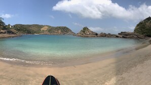A beach with clear turquoise water, a sandy shore, and rocky outcrops. - Cozy property just a 3-minute walk from the beach (Free Wifi Room Service) (Buzios)