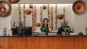 A reception desk with a wooden panel, a Dell computer, and a sign for 'Pool Towels'. - Clarion Inn & Suites (Mission)