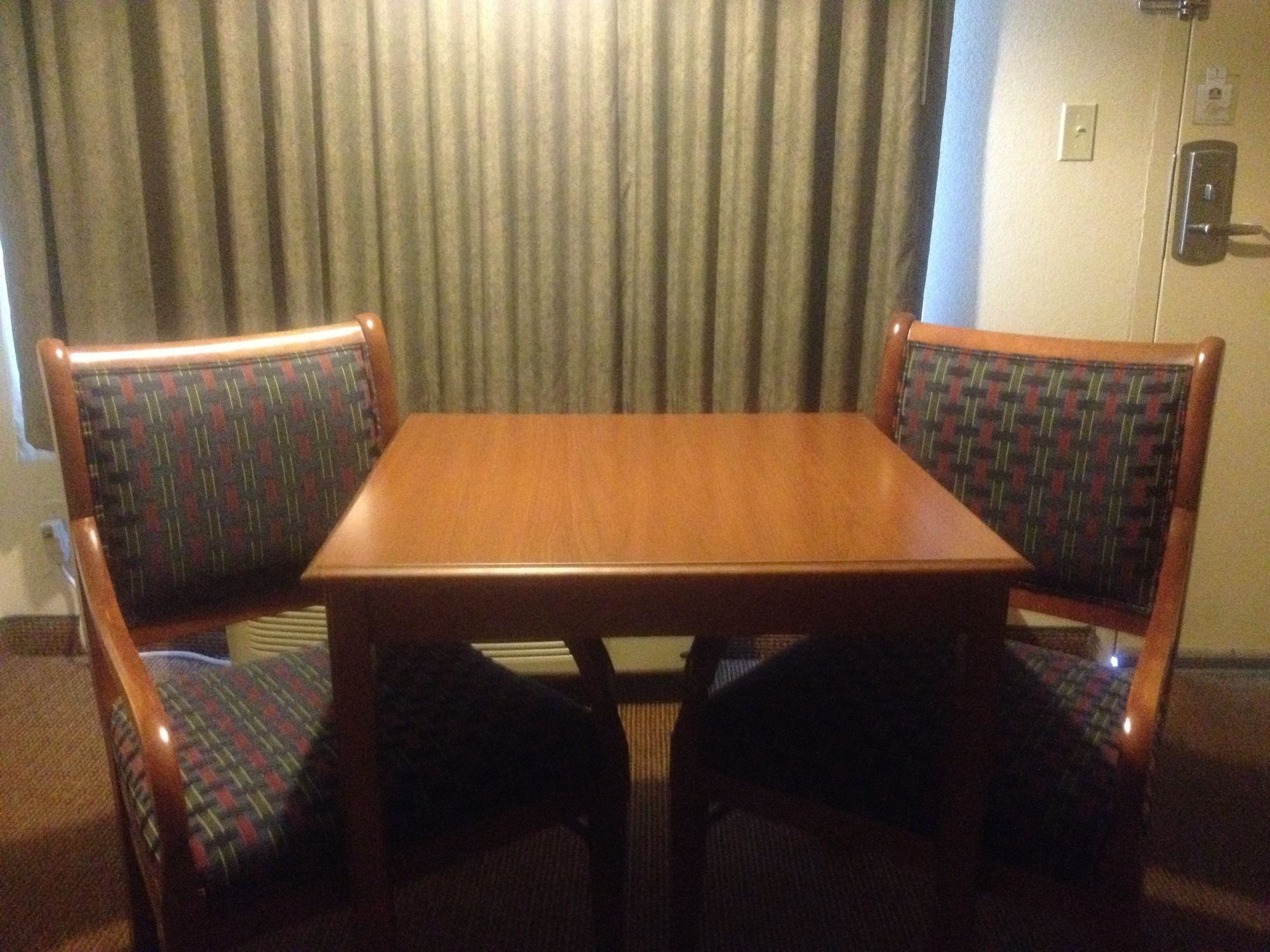 A small wooden table with two upholstered chairs.