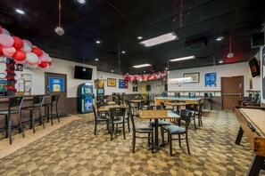 A restaurant with tables and chairs, a jukebox, and a pool table. - Quality Inn Chickasha (Chickasha)