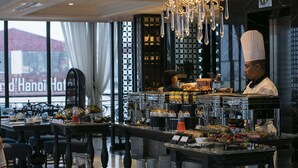 Un buffet garni de divers plats, avec un chef cuisinier en arrière-plan.