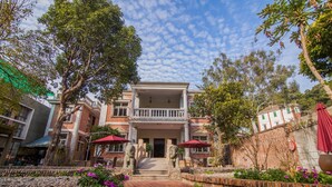 A two-story building with a balcony, surrounded by trees and a cobblestone pathway. - Xiamen Yunpin Hotel (Xiamen)