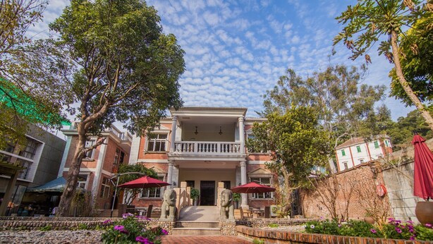 A two-story building with a balcony, surrounded by trees and a cobblestone pathway. - Xiamen Yunpin Hotel (Xiamen)