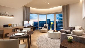 A modern living room with a TV, dining area, and seating.