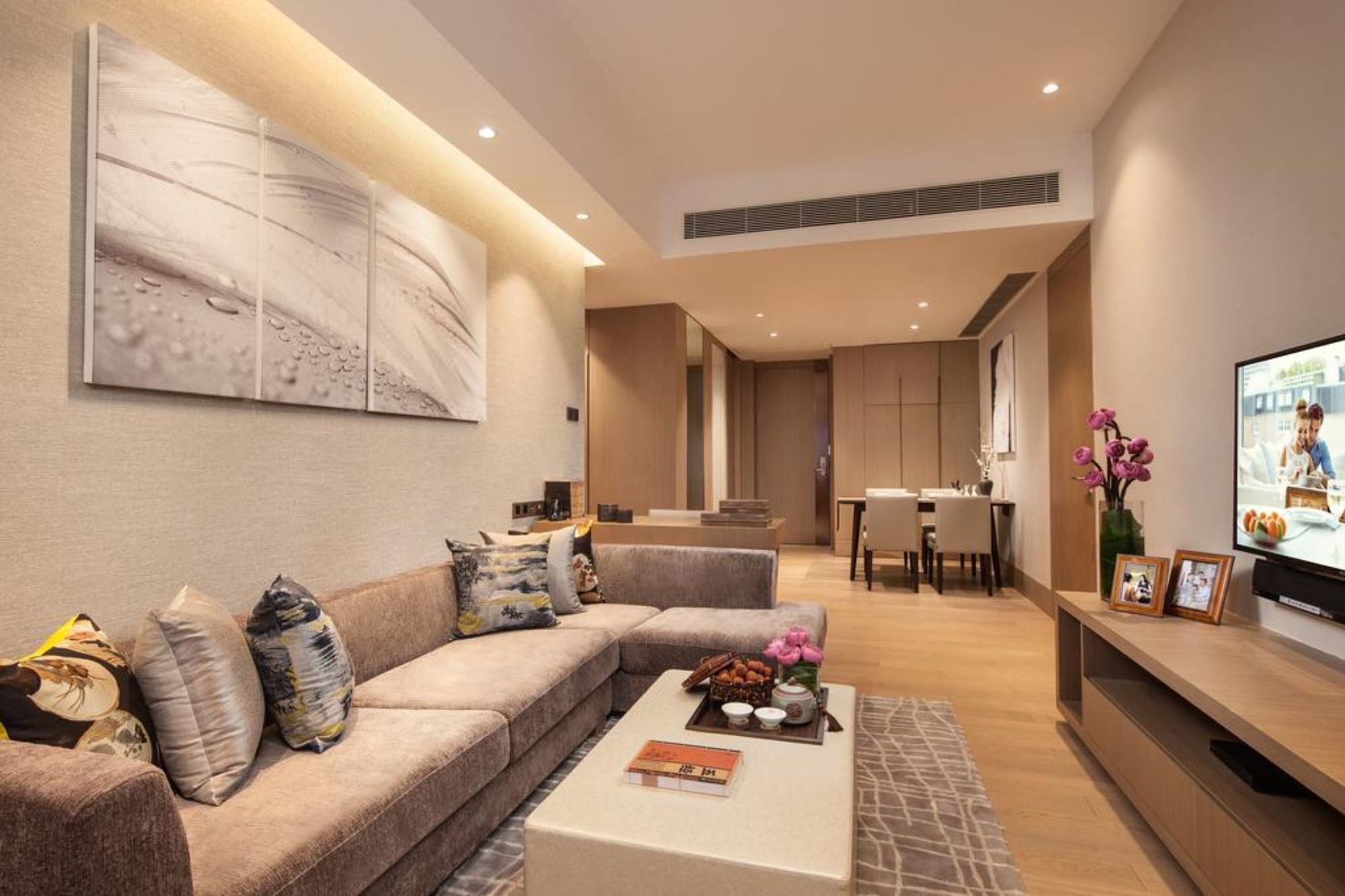 A modern living room with a sofa, coffee table, and artwork on the wall.
