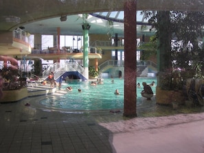 Ein Innenpool mit mehreren Ebenen, einer Wasserrutsche und verschiedenen Wasserspielen.