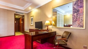 A hotel room with a wooden desk, a chair, a television, a large mirror, and a red carpet. - Yangfang Shengli Hotel (Beijing)