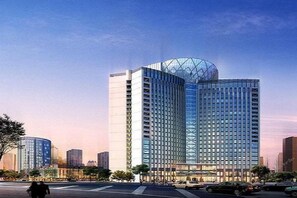 A modern high-rise building with a glass facade and a distinctive spherical structure on top. - T-Longee Hotel (Beijing)