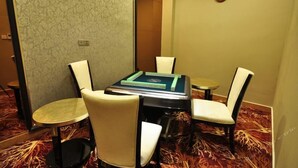 Une salle de conférence avec une table ronde, quatre chaises et une horloge au mur.