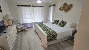 A bedroom with a bed, a TV, a desk, a chair, and a lamp. - Spacious South Venice Home (Venice)