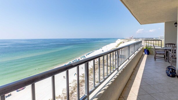 Ein Balkon mit Blick auf Strand und Meer.