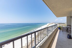 Un balcon avec vue sur une plage et l’océan.