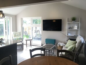 En moderne stue med TV, møbler og udsigt ud.