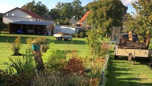 A residential area with a grassy lawn, a wooden fence, and a parked truck. - Bunte Stadt an der Elde (Grabow)