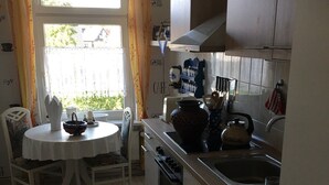 A kitchen with a dining table, chairs, a stove, and a sink. - Bunte Stadt an der Elde (Grabow)