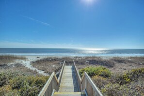 A wooden boardwalk leading to a beach with sand and sparse vegetation. - Sandy Shore: Oceanfront Condo Walking Distance to Golf Course (Caswell Beach)