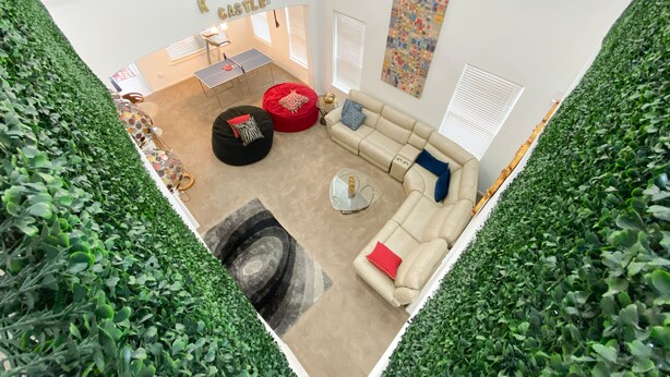 A modern living room with a sofa, ottoman, and a ping pong table. - Beautiful 2 story luxury home in an upscale area! (Houston)