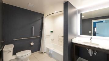 Une salle de bain moderne équipée de toilettes, d’une baignoire et d’un meuble-lavabo.