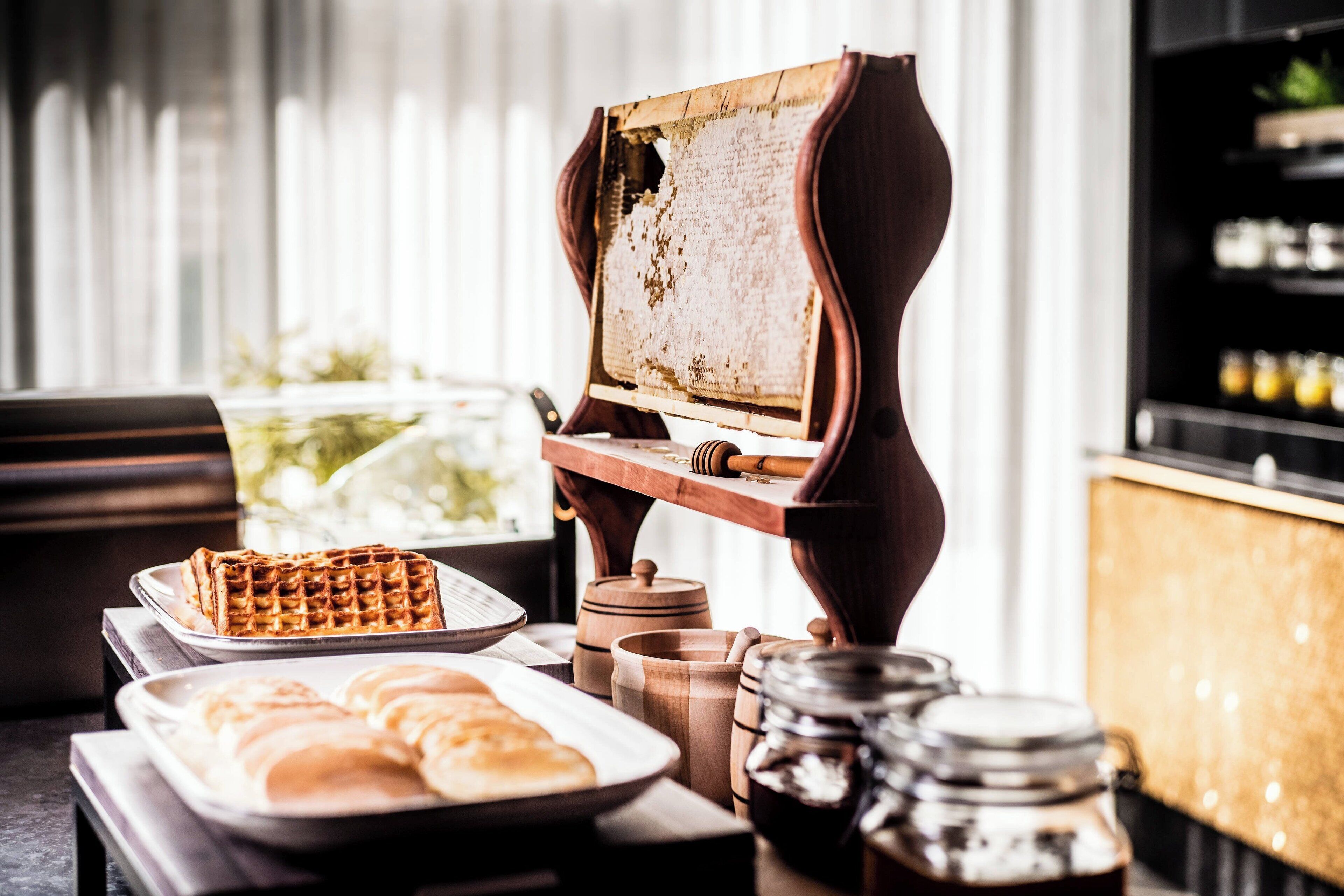 Un ricco buffet per la colazione con waffle, dolci e un angolo caffè.