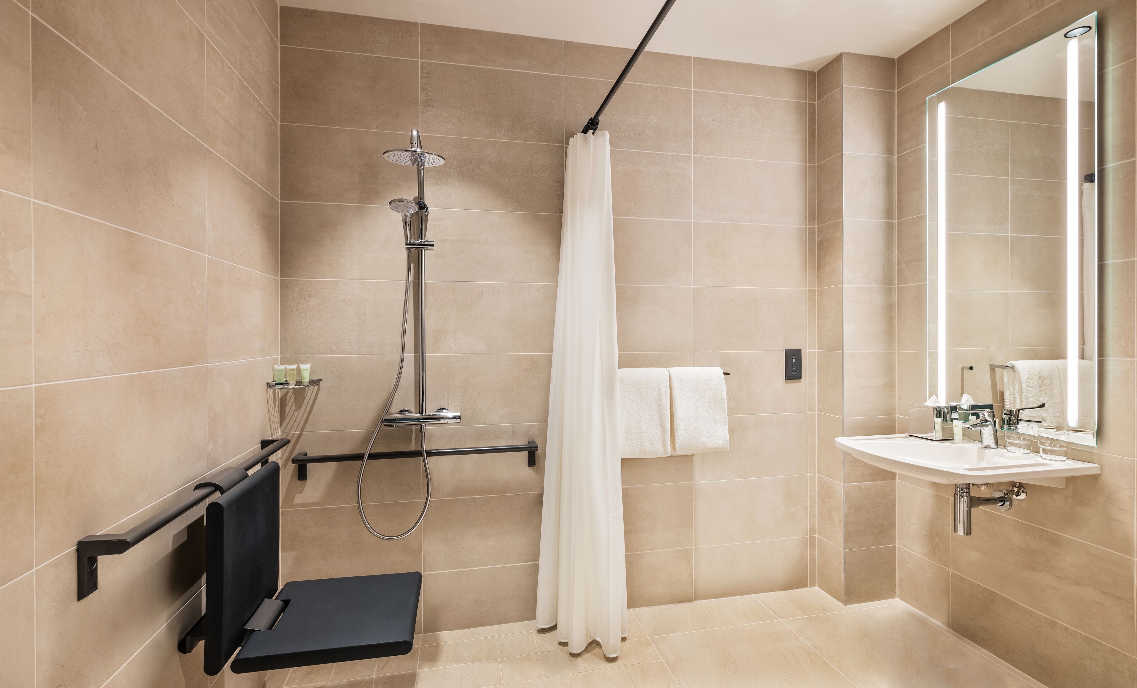 A modern bathroom with a shower, a sink, and a mirror.