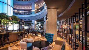A modern interior with a bar area, seating, and a bookshelf.