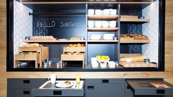 A breakfast buffet with various pastries, bread, and fruits.