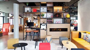 Una sala de estar moderna con sofá, sillas, una mesa de centro y una chimenea.