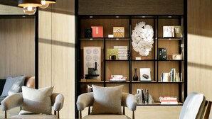 Ein modernes Wohnzimmer mit Holzmöbeln, einem Bücherregal und Pendelleuchten.