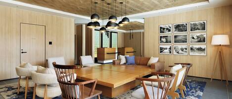 Un comedor moderno con una mesa de madera, sillas e iluminación colgante.
