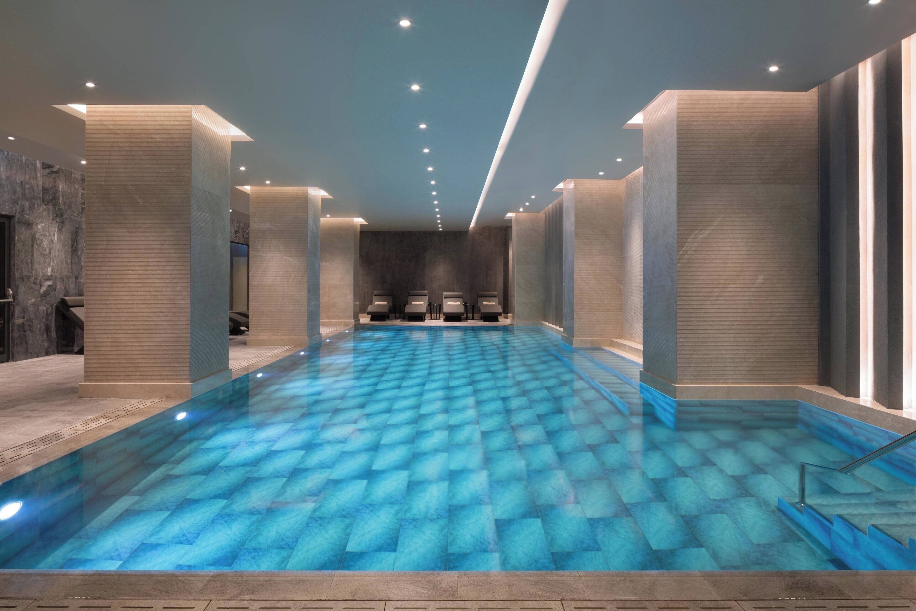 Una piscina techada, una piscina al aire libre de temporada, sombrillas