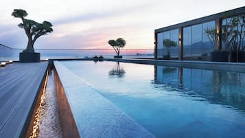 Una piscina techada, una piscina al aire libre de temporada, sombrillas