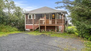 A two-story house with a wooden deck and a covered porch. - Raven Lodge, Amazing Location and Epic Views, Sleeps 10 (Seward)