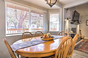Enjoy meals in this cozy dining area with a round table for four, featuring a placemat and a bowl of fresh fruit.