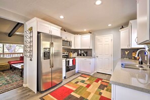 Enjoy cooking in this well-equipped kitchen with a refrigerator, microwave, oven, and sink, and take in the view of the outdoor patio area.