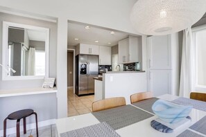 A modern kitchen with white cabinets, a stainless steel refrigerator, and a central island.
