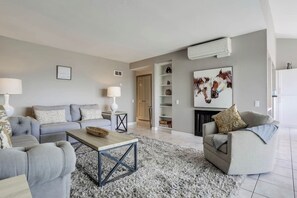 Una sala de estar moderna con un sofá gris, una mesa de centro y una chimenea.