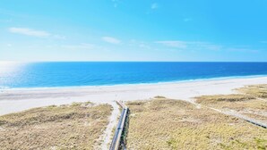 Un paysage côtier avec une plage de sable et un ciel bleu dégagé.