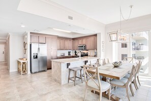 A modern kitchen with a central island, stainless steel appliances, and wooden cabinetry.