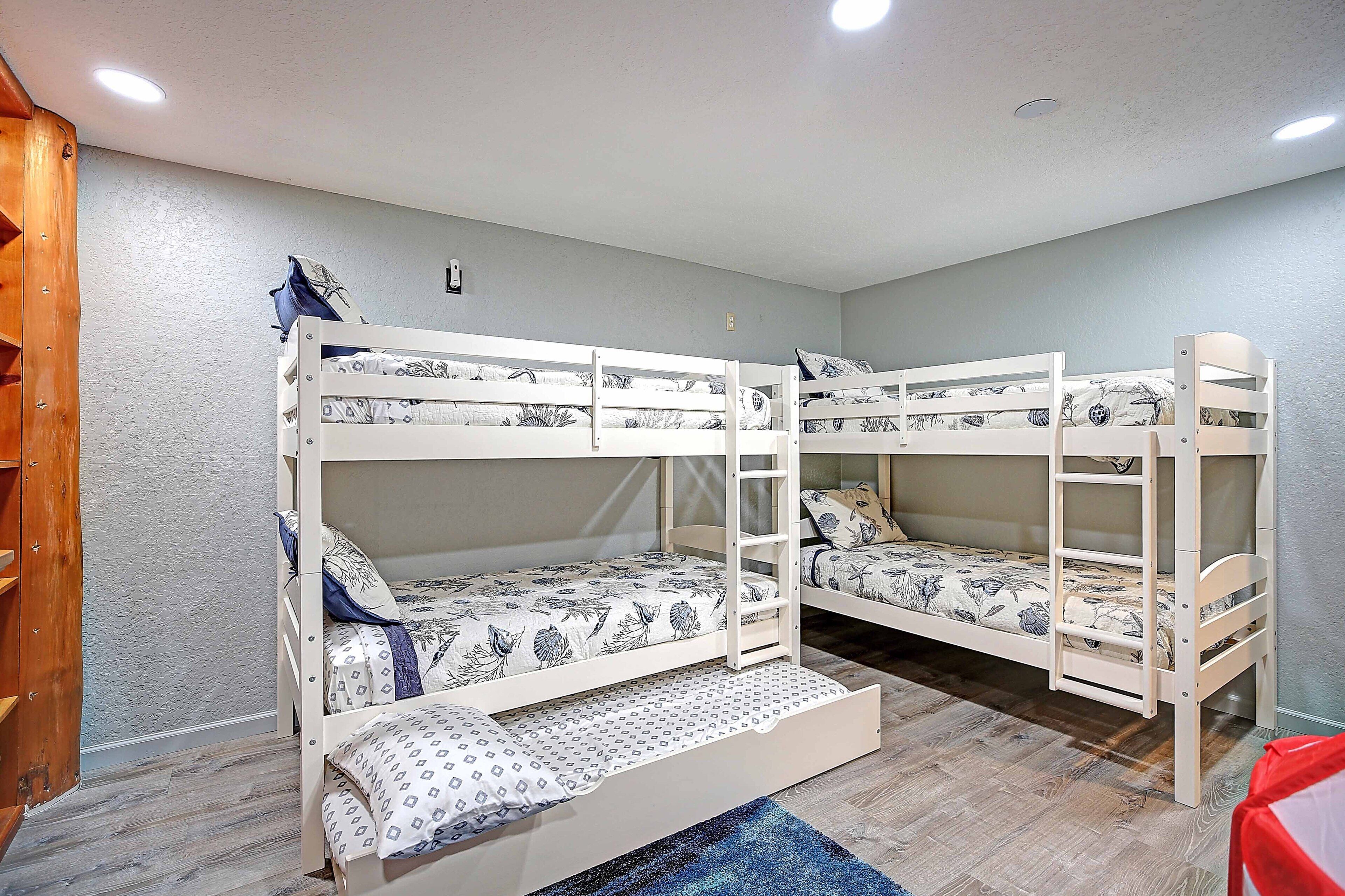 A room with bunk beds, a wooden wardrobe, and a patterned rug.