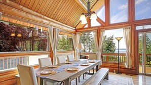 Un comedor de madera con una mesa grande, sillas y bancos.