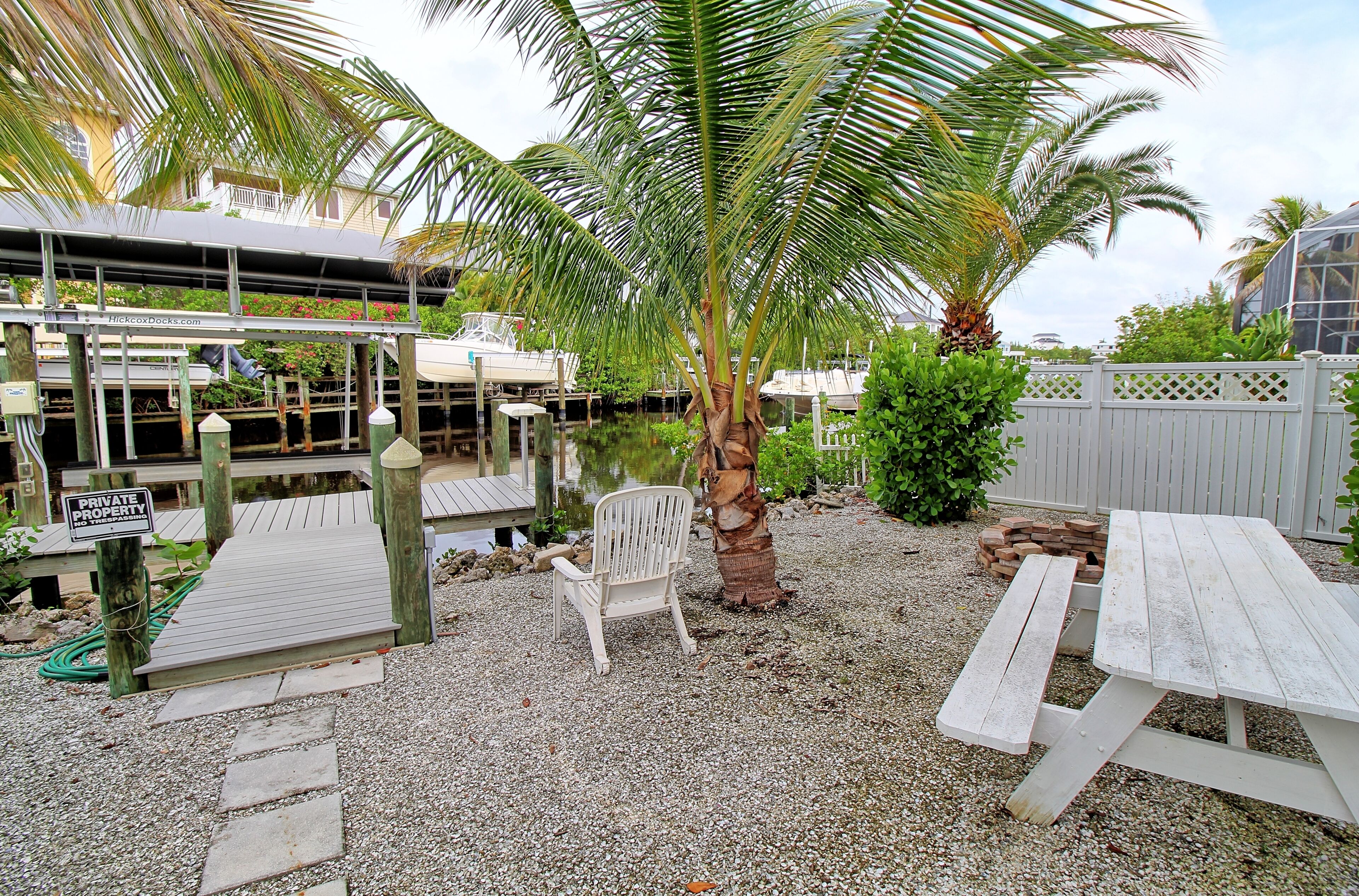 A private dock area with a boat, a chair, and a picnic table.