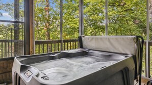 Ein Whirlpool in einer überdachten Außenbereitschaft mit Blick auf Bäume.