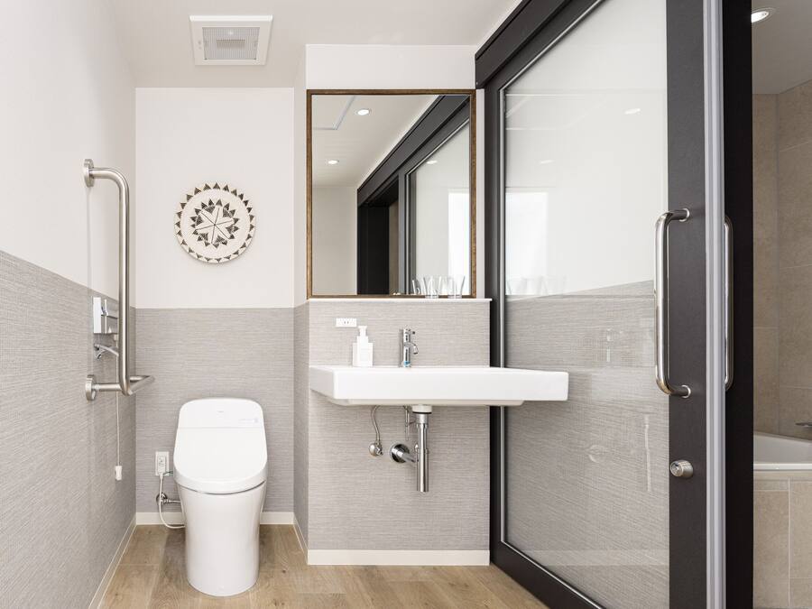 Un baño moderno con inodoro, lavabo y zona de ducha.
