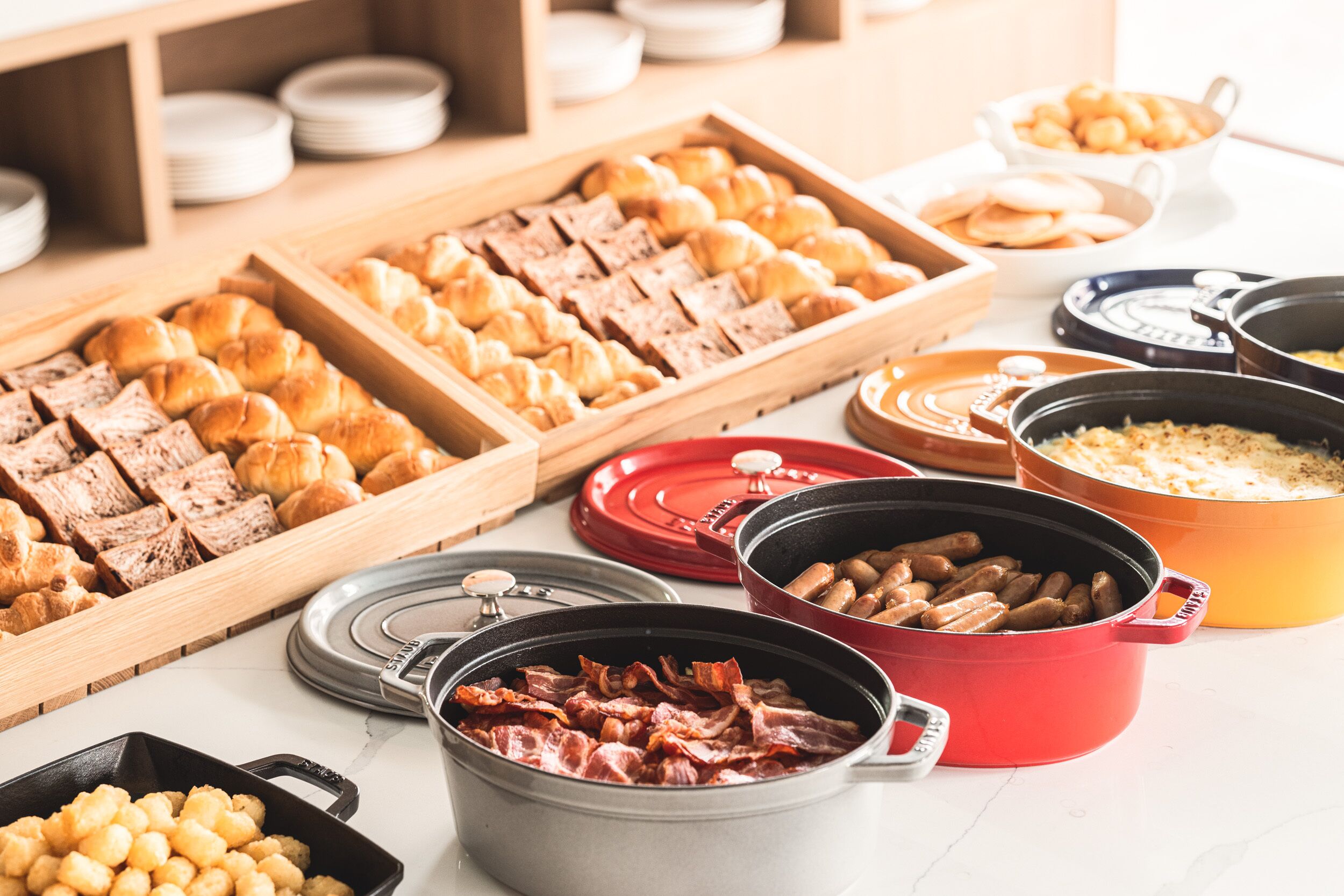 A buffet with various food items including pastries, meats, and casseroles.
