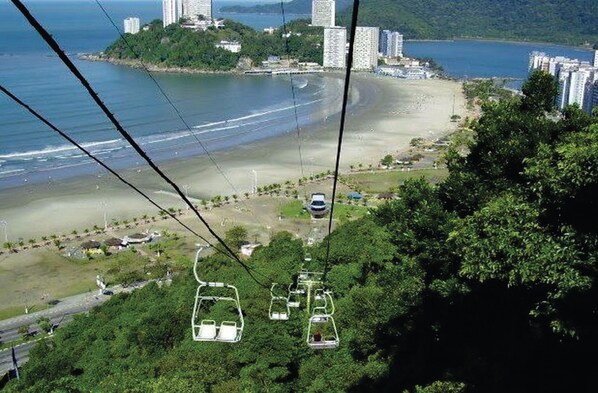 A cable car system with a beach and buildings in the background.